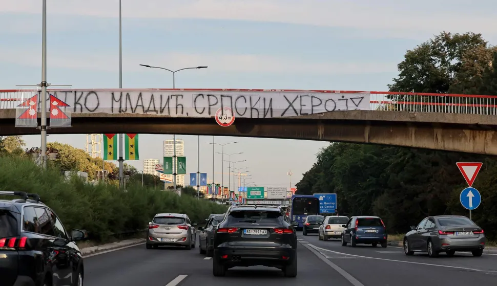 A banner reading "Ratko Mladic, Serbian Hero" is displayed on a footbridge over a motorway as a convoy carrying the body of Bosnian Serb war criminal Ratko Mladic passes through Belgrade, Serbia, on September 3, 2026. Mladic's body arrived in Serbia earlier in the day and was driven from the airport under police escort after being received with military honours. Mladic died the previous week while serving a life sentence for genocide, war crimes and crimes against humanity committed during the 1992-1995 Bosnian war. (Photo by Pedja MILOSAVLJEVIC/AFP)