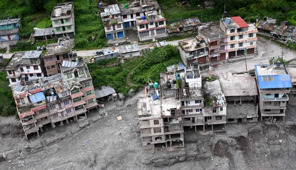 An aerial view shows houses damaged and deluged in sludge in the aftermath of flash floods at Syabrubesi in Nepal's Rasuwa district on September 3, 2026. More than 1,200 people have been killed and nearly 5,000 are missing on both sides of the China-Nepal border since the catastrophic glacial mountain collapse on August 26, according to tolls by both nations on September 3. (Photo by Prakash MATHEMA/AFP)