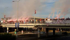 A group of people gathered on a footbridge over a motorway light flares while holding a banner reading "General" as they greet a convoy carrying the body of Bosnian Serb war criminal Ratko Mladic as it passes through Belgrade, Serbia, on September 3, 2026. Mladic's body arrived in Serbia earlier in the day and was driven from the airport under police escort after being received with military honours. Mladic died the previous week while serving a life sentence for genocide, war crimes and crimes against humanity committed during the 1992-1995 Bosnian war. (Photo by Pedja MILOSAVLJEVIC/AFP)