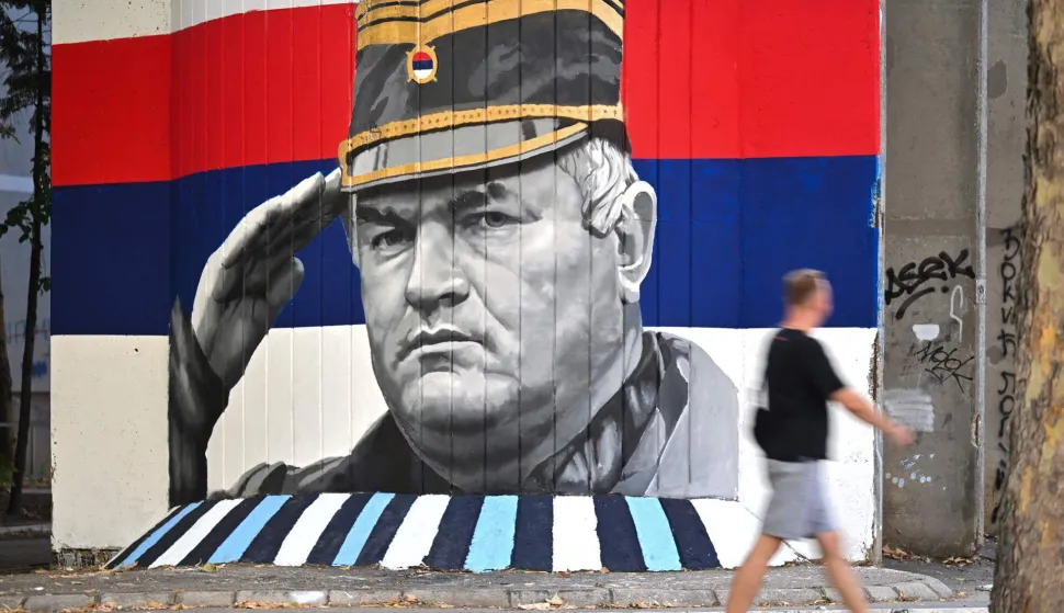 A man walks past a mural depicting former Bosnian Serb military chief Ratko Mladic, who is due to be buried at Belgrade's Topcider Cemetery on September 7, 2026, amid EU criticism over the "glorification" of a war criminal convicted of genocide, in Belgrade on September 6, 2026. Mladic died last week after suffering several strokes while serving a life sentence in The Hague for war crimes committed during the 1990s war in Bosnia. (Photo by OLIVER BUNIC/AFP)
