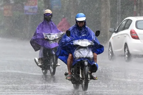 Motorcyclists ride in the rain in Hanoi on September 9, 2026. (Photo by Nhac NGUYEN/AFP)