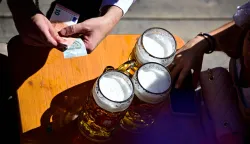 A festival-goer pays for beer after the start Munich's annual beer festival, the Oktoberfest, in Munich, southern Germany on September 19, 2026. The world's biggest beer festival Oktoberfest runs until October 4, 2026. (Photo by Tobias SCHWARZ/AFP)