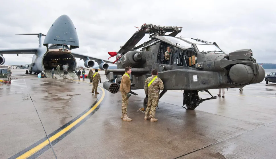 (FILES) An AH-64 Apache attack helicopter stands in front of a Galaxy C-5 transport plane at the US Air Base in Ramstein, western Germany, on February 22, 2017. Germany's defence minister on May 2, 2026, said the withdrawal of American troops from Germany had been expected and that Europe needed to do more to ensure its own security. The Pentagon on May 1, announced the withdrawal of about 5,000 troops from Germany within the next year, the latest rift in transatlantic ties over the Mideast war. (Photo by Martin GOLDHAHN/dpa/AFP)/Germany OUT