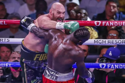 epa09516051 Tyson Fury of England (L) in action against Deontay Wilder of the USA (R) during their 12 round WBC heavyweight world championship title fight at the T-Mobile Arena in Las Vegas, Nevada, USA, 09 October 2021. EPA/ETIENNE LAURENT