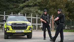 TOPSHOT - Armed police stand guard at an entrance to RAF Fairford base in Fairford, south-west England on September 27, 2026, as UK counter-terrorism police investigate an incident near the base in the village of Whelford. British police on September 27 declared a major incident and evacuated villagers living near a base used by the US air force after arresting several men on suspicion of explosives offences. (Photo by JUSTIN TALLIS/AFP)