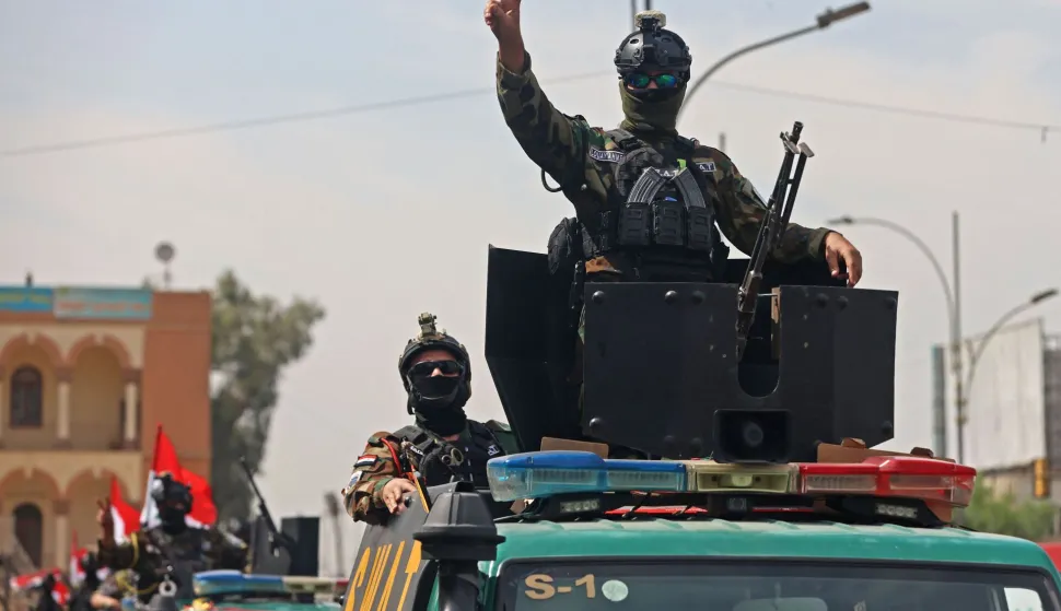 Members of the Iraqi security forces, flash the victory sign during a military parade marking the withdrawal of the US-led coalition from Iraq, in Baghdad on September 30, 2026. A US-led coalition deployed in Iraq more than a decade ago to fight jihadists concluded its mission on September 30, a move celebrated by the country's leaders, but which some fear will embolden pro-Iran armed factions. (Photo by AHMAD AL-RUBAYE/AFP)