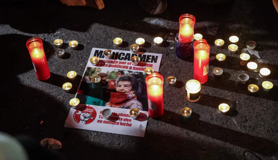 A flyer with an image of Maricarmen Abascal, the 87-year-old pensioner whose eviction triggered nationwide protests over Spain's chronic housing crisis and a political debate that culminated in early elections, is seen at an impromptu protest vigil after she died in hospital in Madrid on October 7, 2026. Abascal became a symbol of Spain's housing market on September 23 when she was evicted from her life-long Madrid home on a stretcher after the real estate firm that owned the apartment drastically hiked the rent. (Photo by Thomas COEX/AFP)