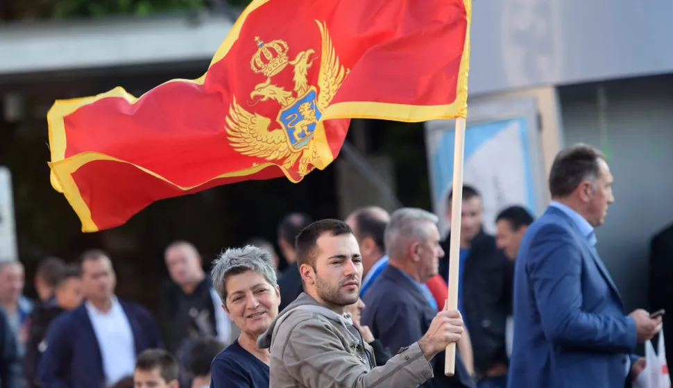epa05321914 A man holds the Montenegrin flag at the Independence Square during the celebrations for the country's 10th anniversary of its Independence Day in Podgorica, Montenegro, 21 May 2016. EPA/BORIS PEJOVIC