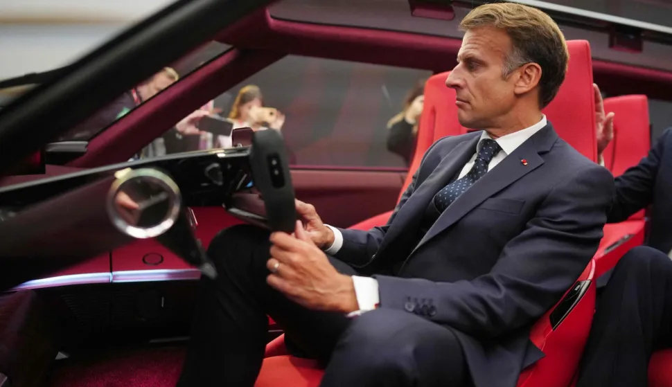 France's President Emmanuel Macron sits inside a prototype of Renault E-Space car as he visits Renault stand at the international Paris Motor Show at the Porte de Versailles in Paris on October 12, 2026. (Photo by Thibault Camus/POOL/AFP)