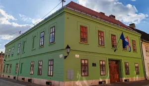 O jednokatnici sagrađenoj na jugozapadnom uglu Ulice Franje Kuhača i Ulice dr. Danice Pinterović već smo pisali u ovoj kolumni, a razlog za objavu jo&scaron; jednog teksta je upravo dovr&scaron;ena obnova njezina pročelja.listopad 2026.
