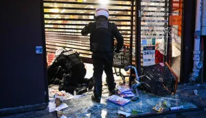 Police officers detain a person at a ransacked Franprix store as clashes erupted at Place de la Republique following an unauthorised demonstration, central Paris, on October 18, 2026 a day after nationwide protests against the "high cost of living". France's Prime Minister Sebastien Lecornu said 1,200 people were arrested in protests across the country on October 17, and 150 police were hurt as clashes between police and protesters, massive looting and multiple blazes gripped France as nationwide marches against soaring inflation degenerated into street violence of "extreme intensity". (Photo by Matthieu RONDEL/AFP)