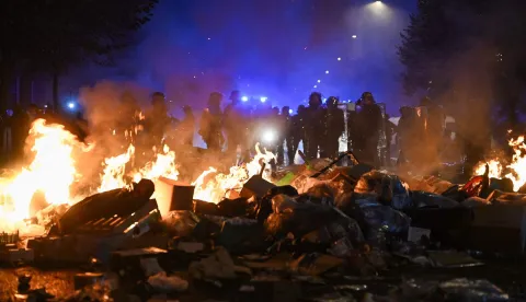 Police officers stand behind a fire near Place de la Republique following an unauthorised demonstration, central Paris, on October 18, 2026 a day after nationwide protests against the "high cost of living". France's Prime Minister Sebastien Lecornu said 1,200 people were arrested in protests across the country on October 17, and 150 police were hurt as clashes between police and protesters, massive looting and multiple blazes gripped France as nationwide marches against soaring inflation degenerated into street violence of "extreme intensity". (Photo by Matthieu RONDEL/AFP)