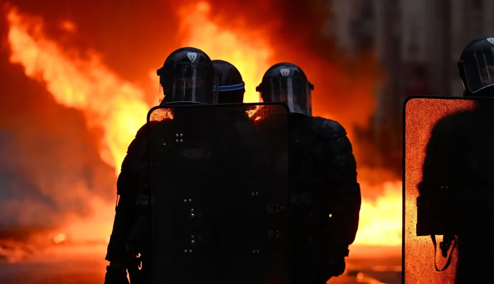 TOPSHOT - Police officers stand in front of flames as clahes erupted on the sidelines of a demonstration in favor of purchasing power, the protection of public services, and fiscal and social justice, in Nantes, western France on October 24, 2026 as part of a nationwide call for mobilisation bringing together former members of the Yellow Vest movement, labor unions, high school and university students. Protests by high school students over learning conditions sparked a movement that has since spread nationwide, fuelled by broader anger over the rising cost of living. About 70,000 security personnel will be deployed on October 24, 2026, Interior Minister said at a news conference, warning that calls for violence and looting were circulating on social media. (Photo by Guillaume Saligot/AFP)