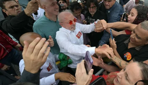 Brazil's President and Workers' Party (PT) re-election candidate Luiz Inacio Lula da Silva, wearing star-shaped glasses, greets supporters outside a polling station during the presidential runoff election in Sao Bernardo do Campo, Sao Paulo state, Brazil, on October 25, 2026. Lula da Silva faces right-wing senator Flavio Bolsonaro in a runoff that will determine whether Brazil remains one of the few leftist nations in the region or joins a regional swing to the right championed by US President Donald Trump, Bolsonaro's ally. (Photo by NELSON ALMEIDA/AFP)