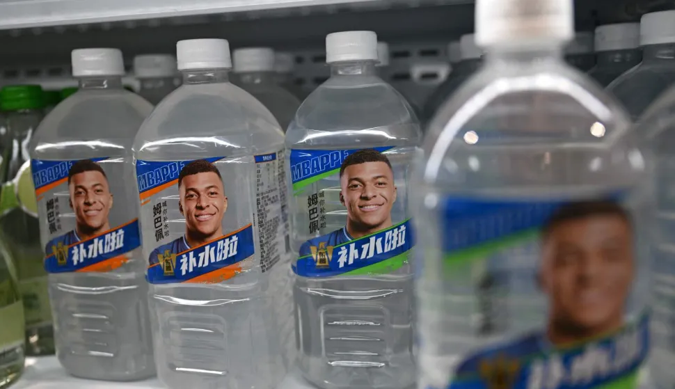 Bottles of Dongpeng Beverage Group's "Bushuila" electrolyte drink featuring French football star Kylian Mbappe on the packaging are displayed at a convenience store in Beijing on October 27, 2026. Kylian Mbappe was dropped October 27 by two major brands in China after a video circulated online in which the French football star apparently joked about former leader Mao Zedong. (Photo by Pedro PARDO/AFP)